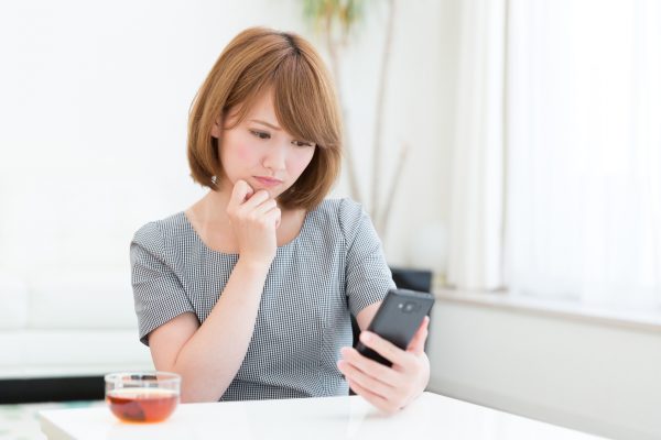 街コンレポート＿スマホを見ながら悩んでいる女性