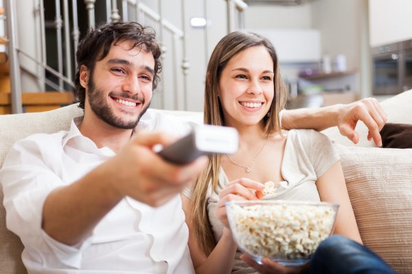 街コンレポート＿カップルがソファーに座ってテレビを見ている