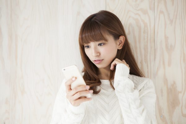 街コンレポート＿女性が携帯電話を見ています