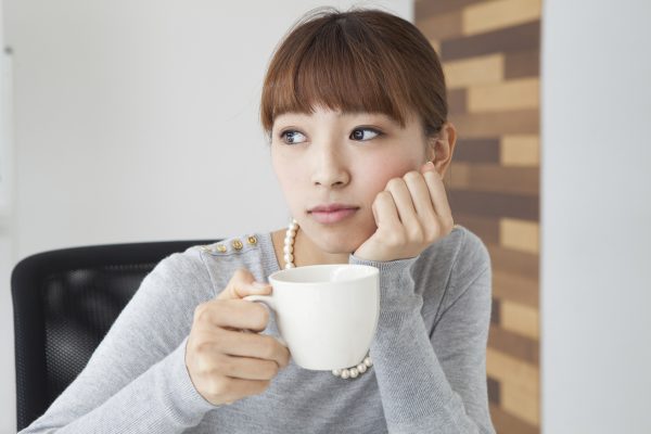 街コンレポート＿女性が悩まし気にコーヒーを飲んでいます