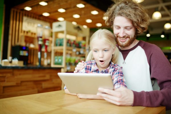 街コンレポート＿父が娘にタブレットを見せている