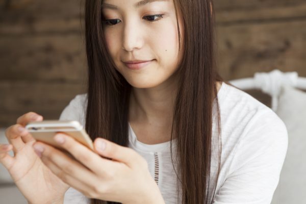 街コンレポート＿女性が携帯電話を眺めています